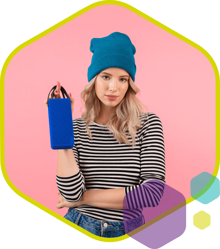 Vrouw met blauwe muts toont draagbare speaker als promotioneel product