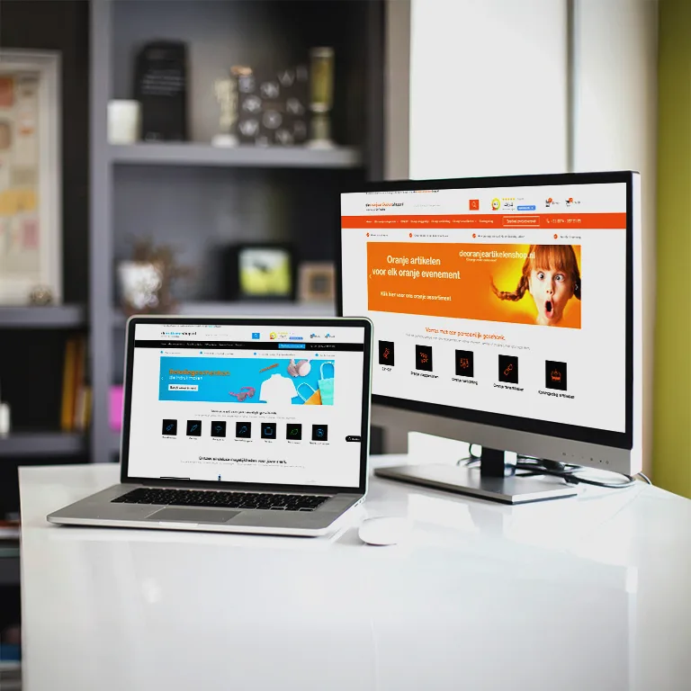Laptop en beeldscherm tonen webshops met relatiegeschenken en oranje promotieartikelen.